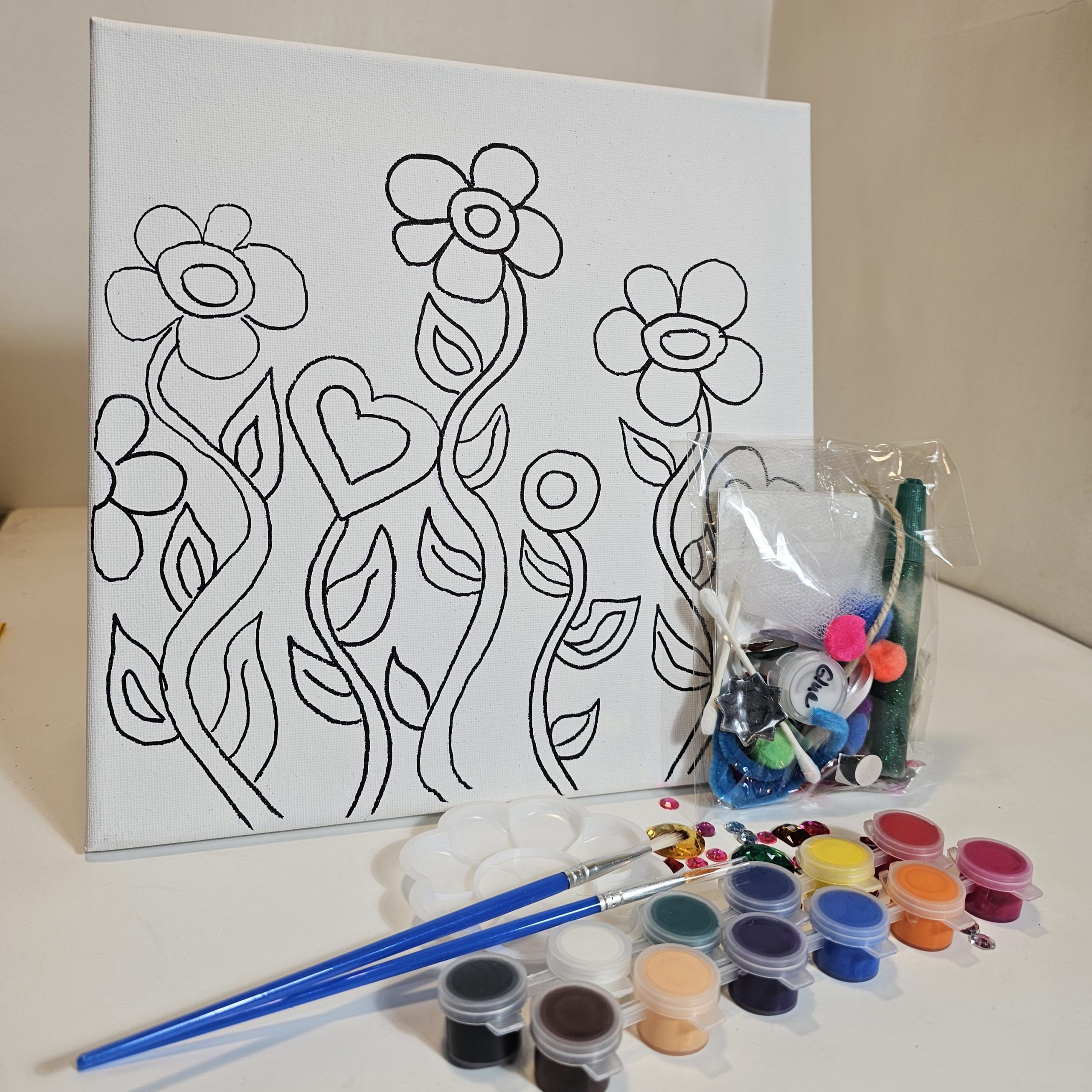 Creative You kit for Dancing Blooms with paint, glue, and collage materials surrounding the canvas