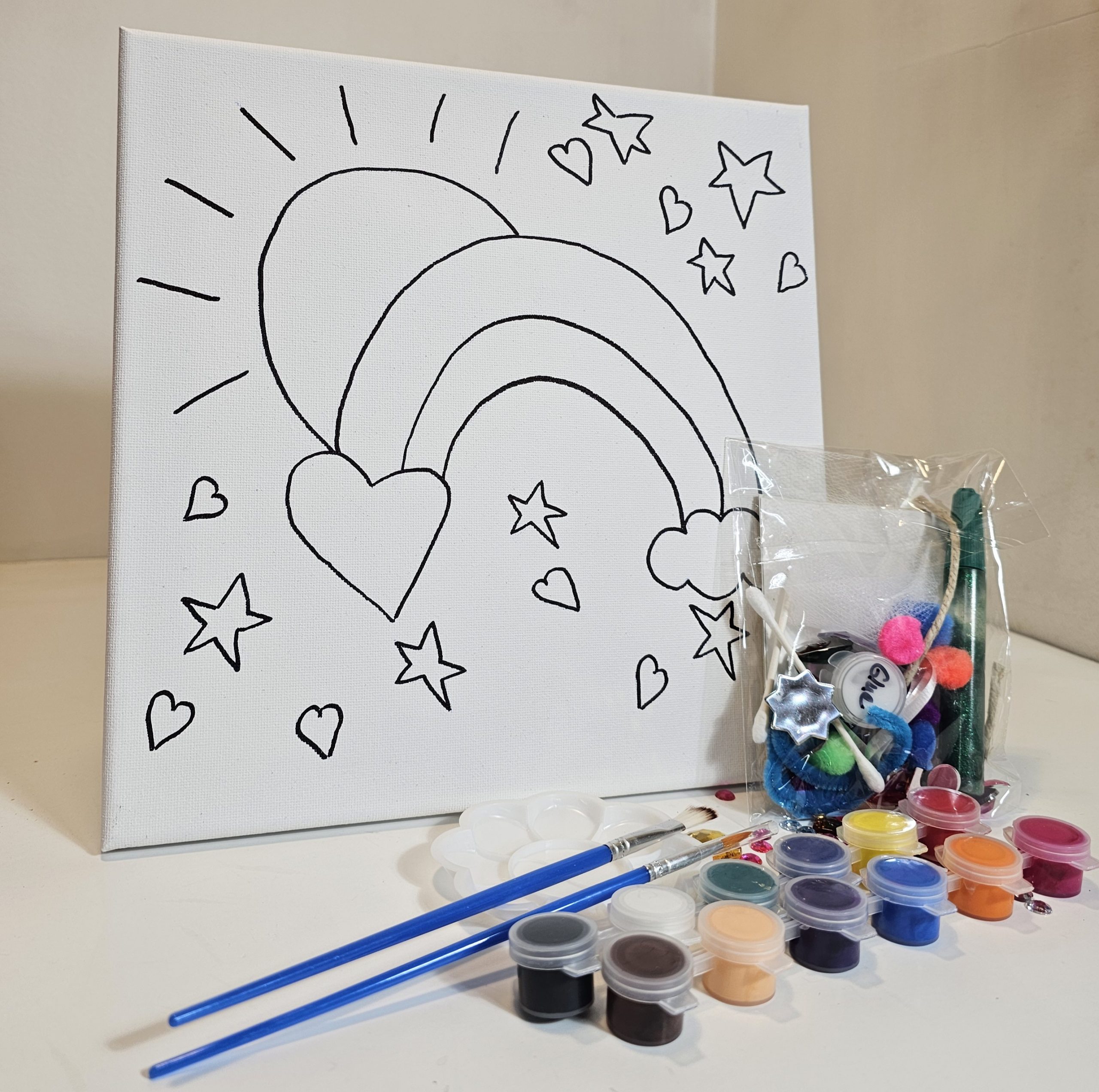 Kit with rainbow canvas, paints, glue, collage elements