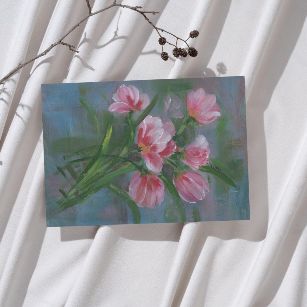 Red & Pink Tulips greeting card laying on soft fabric with a small natural branch, styled in warm light.