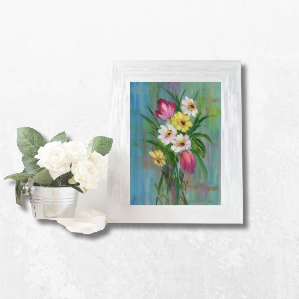 Greeting card with bright florals displayed in a white frame on a tabletop