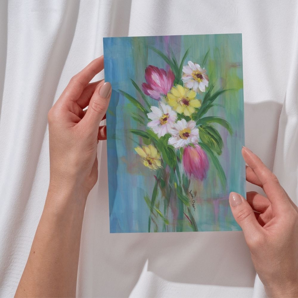 Woman holding a spring bouquet greeting card featuring daisies and tulips