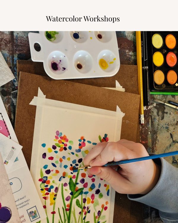 Hand painting colorful watercolor flowers during a guided watercolor workshop.